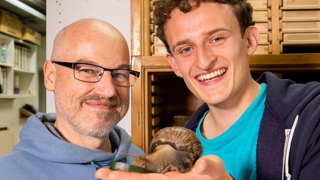 Bild: BR/megaherz gmbh/Markus Schindler Checker Julian hält eine Afrikanische Riesenschnecke in seiner Hand.