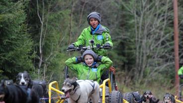 Elias und Johannes genießen die rasante Fahrt mit dem Trainingsschlitten.