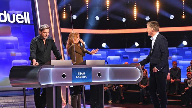 Moderator Jörg Pilawa mit den Kandidat:innen des Teams "Kamera": Dem Schauspieler Stefan Jürgens und die Schauspielerin Esther Schweins.