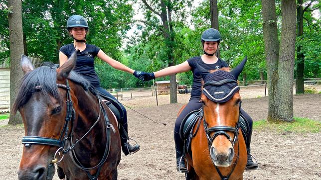 Sara mit Pferd Amazone und Lena mit Pferd Merli. Die beiden voltigieren leidenschaftlich gerne und lieben ausgedehnte Ausritte.