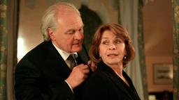 Staatsminister Tannenberger (Michael König) hilft Claire (Senta Berger) beim Schließen ihres Reißverschlusses.