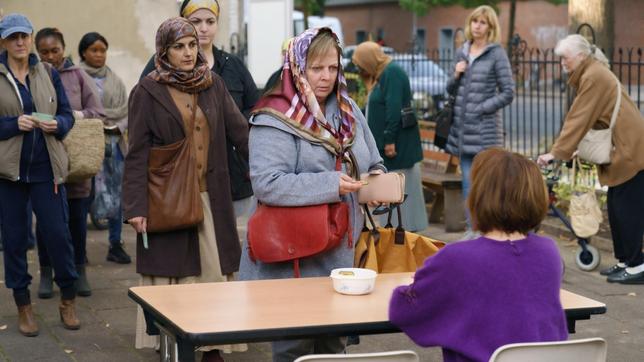 Bild: rbb/ARD/X Filme Creative Pool GmbH/Stefan Erhard Tina steht für die Markenausgabe bei der Tafel an. Hinter ihr wartet auch Fatma, deren Berechtigungsschein mal wieder nicht gültig ist.