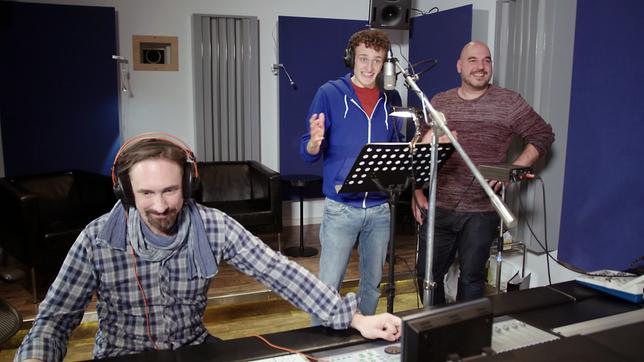 Julian (Mitte) und der Synchronsprecher und Dialekt-Imitator Oliver Lehmann (rechts) synchronisieren in einem Münchner Tonstudio.