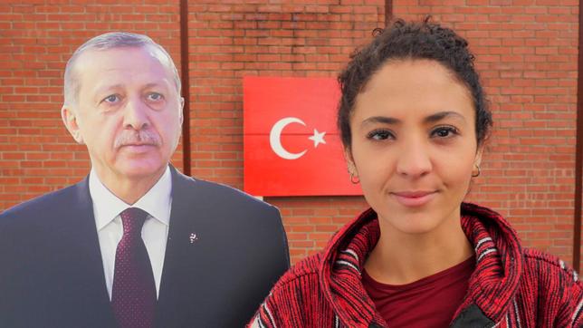 Reporterin Siham mit einer Figur des türkischen Präsidenten Erdogan, im Hintergrund die türkische Nationalflagge.