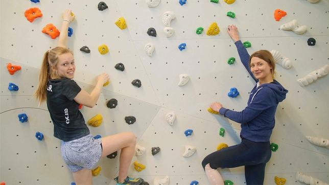 Jana und Nuria stehen startklar an der Kletterwand.