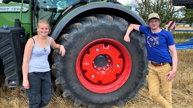 Robert und Landwirtin Anni stehen gemeinsam vor einem Trecker.