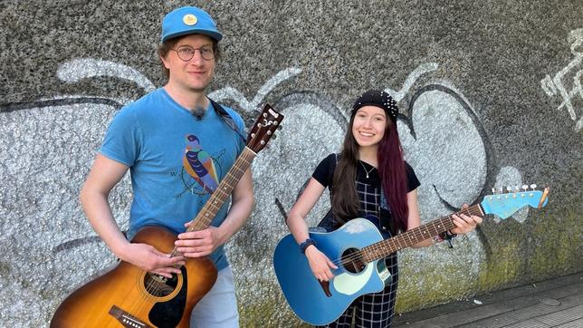 Robert und Sarah Hübers haben ihre Gitarren umgeschnallt, um gemeinsam Straßenmusik zu machen.