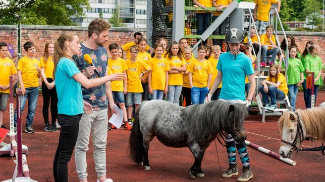 Die Reiterinnen Simone und Fiona vom Ponyhof Müller in Denkendorf sind begeisterte Shetty-Sportlerinnen. Zusammen mit ihrer Trainerin Tanja zeigen sie Moderator Johannes Zenglein, wie der Sport funktioniert und warum er so vielseitig ist.