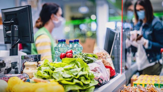 Frau bezahlt Lebensmittel an der Supermarktkasse