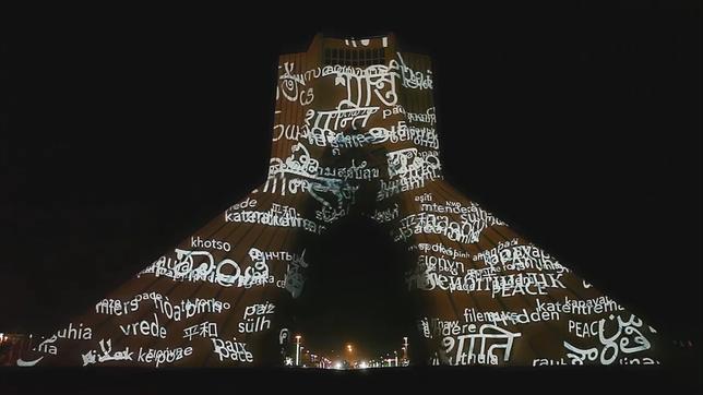 Der Freiheitsturm (Azadi) in Teheran mit einer Videoprojektion mit dem Wort "Frieden" in vielen Sprachen