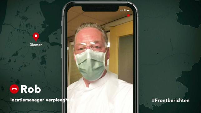 Mann mit Schutzmaske filmt sich selbst mit seinem Handy.