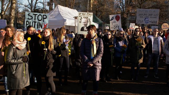 Demonstranten mit Blumen und Plakaten