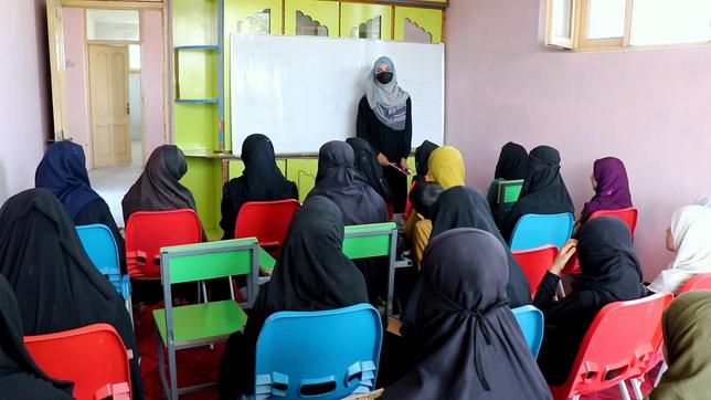 Verschleierte Schülerinnen vor einer Lehrerin an einer Tafel