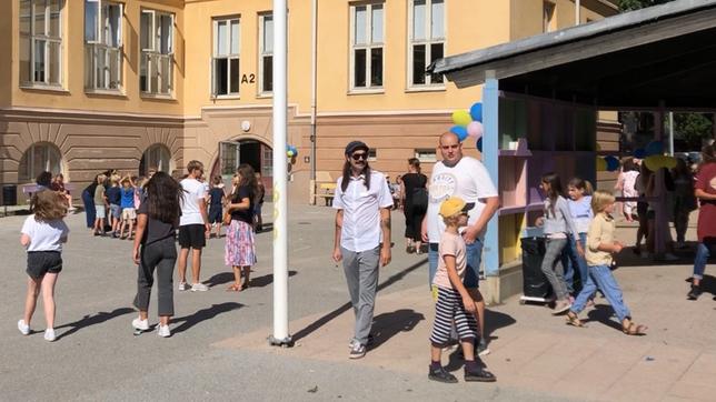 Erwachsene und Kinder in einem Schulhof