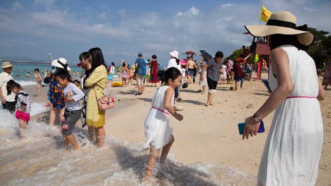 Chinesische Touristen am Strand