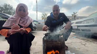 Mann und Frau kochen auf Feuerstelle 