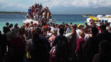 Touristen steigen am Strand von einem Boot 