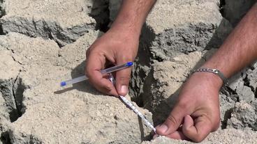 Vertrockneter Boden mit starken Rissen wird vermessen