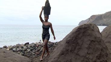 Maria mit einem Eimer Sand auf dem Kopf