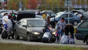 Syrer stehen an Autos