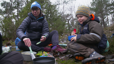 Mutter mit Kind beim Essen im Wald