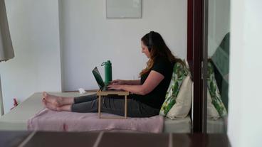 Frau auf Bett mit Laptop 