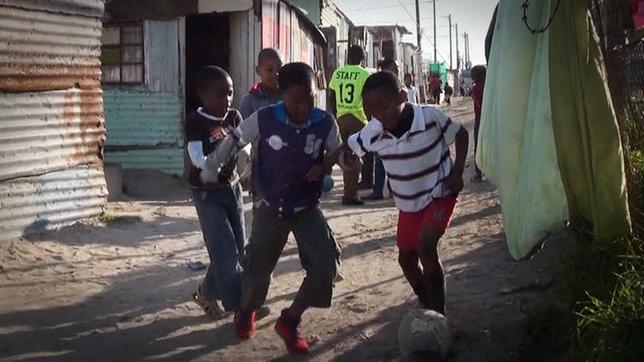 Kinder spielen in Gasse Fußball