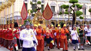 Thailands König wird mit viel Pomp auf einem Stuhl getragen