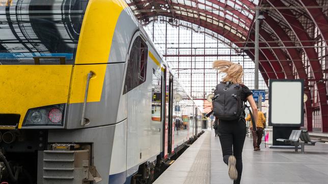 Eine Frau rennt über den Bahnsteig, links steht ein Zug. Jetzt mitmachen bei #besserBahnfahren