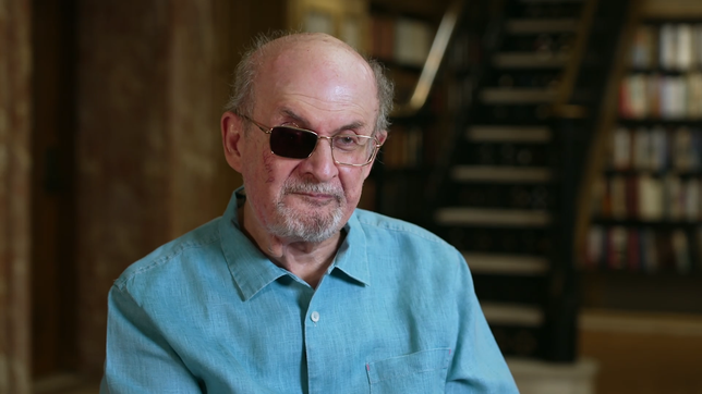 Salman Rushdie sitz auf einem Stuhl.