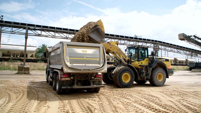 Bagger verlädt Sand auf Lkw