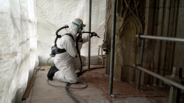 Steinmetz reinigt Kapitelle am Kölner Dom.