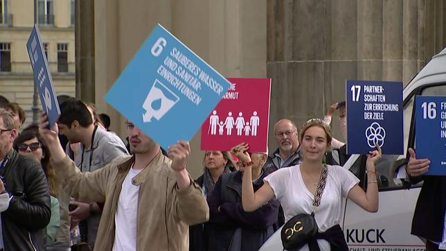 Menschen halten Schilder bei einer Demonstration hoch.