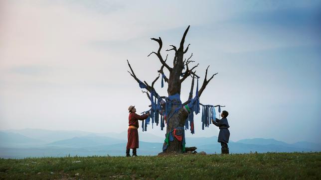 Der 11-jährige Amra (Bat-Ireedui Batmunkh, r.) mit seinem Vater Erdene (Yalalt Namsrai, l.) am Gebetsbaum.