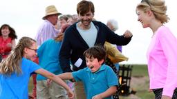 Abi (Rosamund Pike, re.) und Doug (David Tennant) wagen ein ausgelassenes Tänzchen mit ihren Kindern Lottie (Emilia Jones) und Mickey (Bobby Smalldridge, 2. v. re).