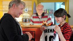 Die fußballbegeisterte Charlie (Annika und Francesca Bolkart) strahlt über ein Geschenk ihres Papas Alex (Jörg Schüttauf); auch Opa Willy (Peter Franke) freuts…