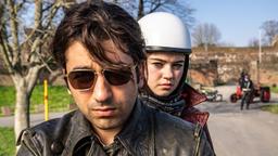 Bijan (Omid Memar) und Betty (Ella Lee) fahren mit dem Motorrad und werden von Schneider (Raphael Westermeier) und seinen Kollegen angehalten und überprüft.