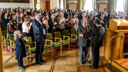 Feierstunde in der Universität: Dekan Prof. Krone (Michael Prelle, vorne links) gratuliert Prof. Boerne (Jan Josef Liefers, vorne rechts) zum neuen Forschungsauftrag – auch Boernes Assistentin Silke Haller (ChrisTine Urspruch, links) applaudiert.