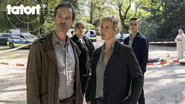 Tatort im Park: Ein Polizist wurde getötet – die Kommissare Peter Faber (Jörg Hartmann), Rosa Herzog (Stefanie Reinsperger), Martina Bönisch (Anna Schudt) und Jan Pawlak (Rick Okon) schauen sich um, während Rechtsmedizinerin hinten rechts) das Opfer untersucht.