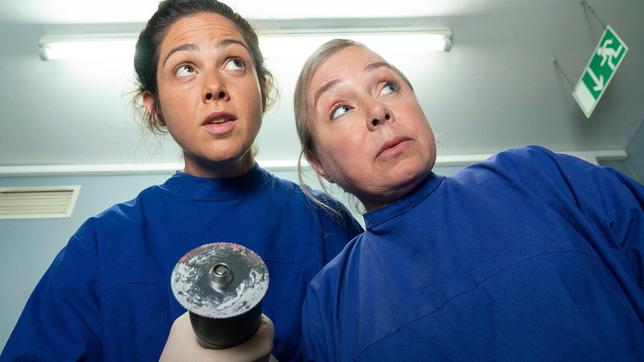 Silke Haller (ChrisTine Urspruch, r) und Vivian Peters (Judith Goldberg) untersuchen Hartnacks Leiche während  Boerne schläft.