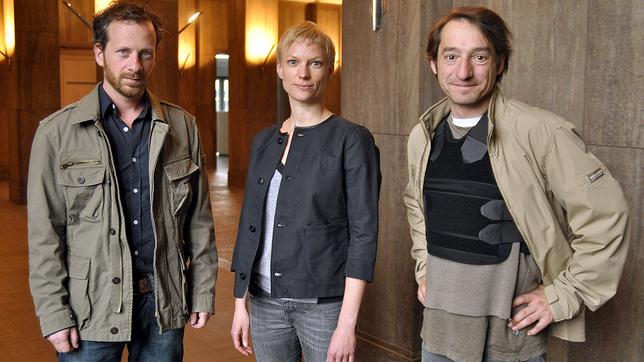 Arbeitsfoto von den Dreharbeiten zu "Die Vorsehung" (AT) (v.l.n.r.): Fabian Busch als Polizeipsychologe Robert Meinhardt, Lise Risom Olsen als norwegische Studentin Trude Bruun Thorvaldsen und Boris Aljinovic als Hauptkommissar Felix Stark in einer kugelsicheren Weste.