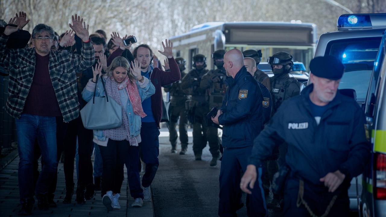 Die Polizei versucht nach der Tötung eines Fahrkartenkontrolleurs die Lage am Bus zu ordnen und bringt die Fahrgäste (Komparsen) in Sicherheit.