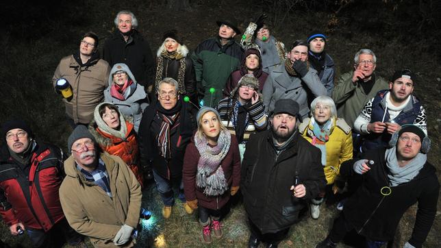 Klara Degen mit ihrem Tom "Ollie" Ollenhauer zusammen mit anderen Menschen auf der UFO-Wiese. 