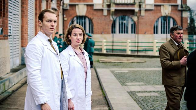 Dr. Ella Wendt (Nina Gummich) und Dr. Alexander Nowack (Max Wagner) schauen entsetzt zum Humboldhafen - der erste Mauertote wird aus dem Wasser geborgen.