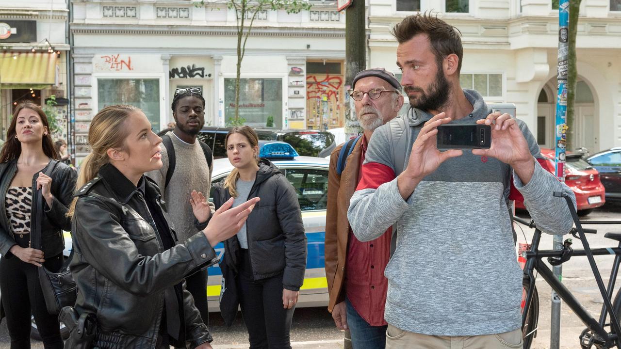 Unangenehme Begleiterscheinung: Bente Hinrichs (Sinha Melina Gierke, 2.v.l. mit Kompars:innen) weist einen filmenden Gaffer am Ort des Verbrechens in seine Schranken.