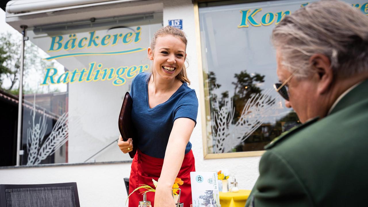 Der tote Journalist Lothar Kolb wurde nackt in seinem PKW gefunden. Hubert und Girwidz (Michael Brandner)  denken bei einem Cappuccino, den ihnen s'Lenerl (Victoria Abelmann- Brockmann) im "Rattlinger" serviert, über den neuen Fall nach.