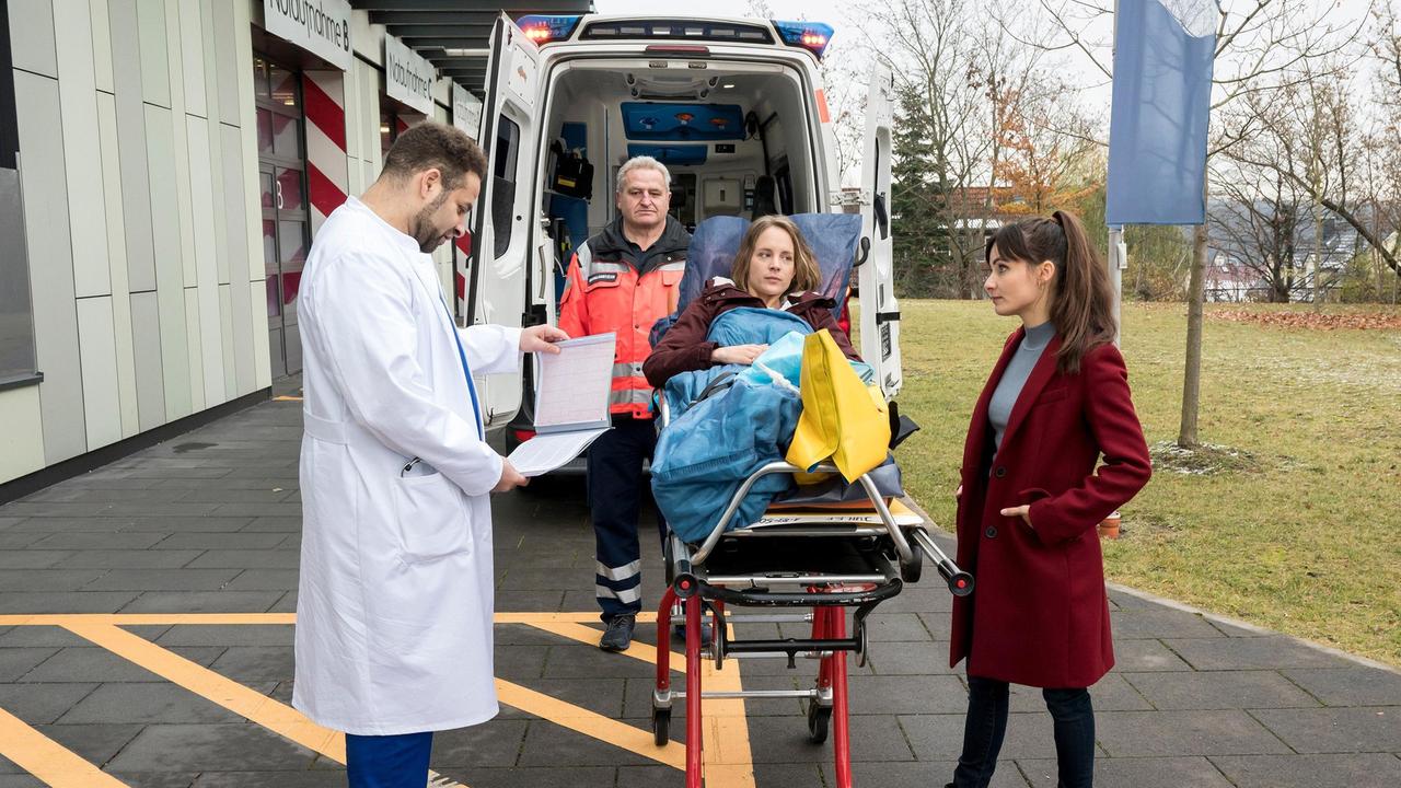 Dr. Annika Rösler (Paula Schramm) übergibt Dr. Moreau (Mike Adler) einen emotionalen Fall: Die junge Dreifachmutter Leonie Bender (Heidrun Pfeil, M. mit Komparse) wurde von einem Traktor schwer verletzt.