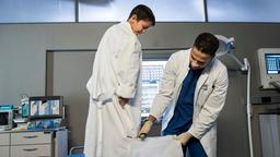 Dr. Matteo Moreau (Mike Adler) schneidet Sami (Maamar Abbou) den geklauten Kittel zurecht.