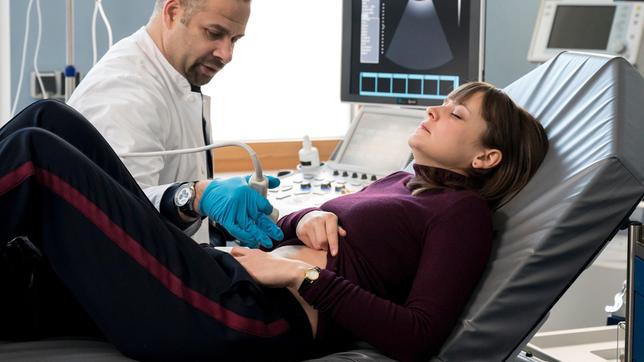 Dr. Moreau (Mike Adler) untersucht Lena-Valentina Mahler (Thekla Hartmann) und stellt eine erste Diagnose.