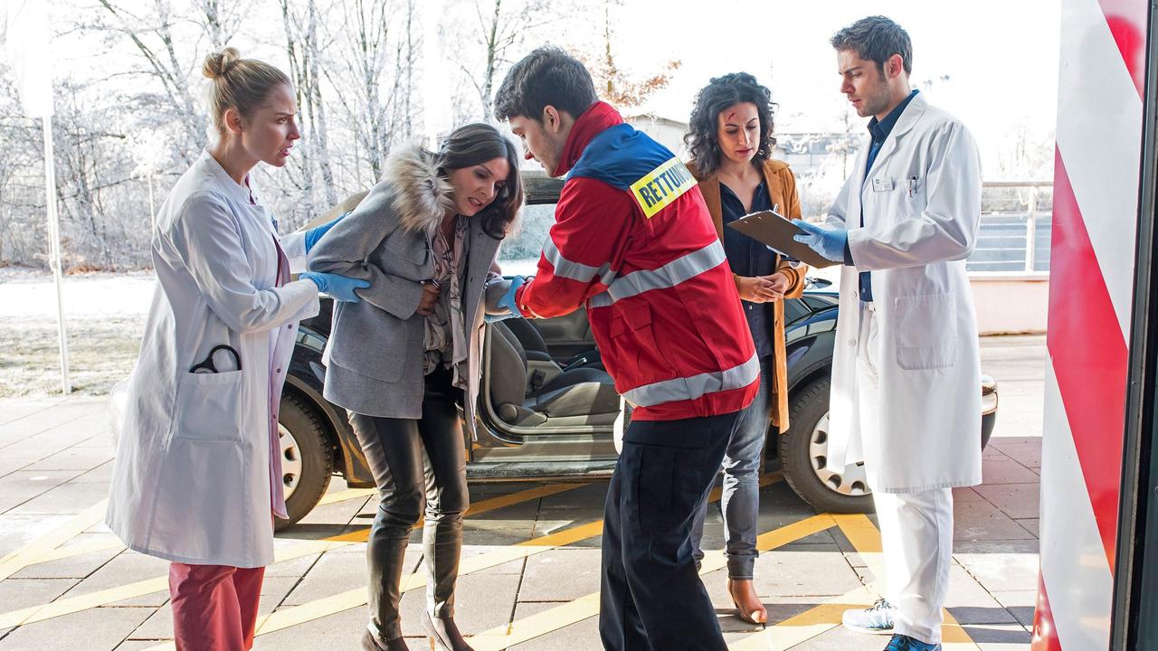 Niklas (Roy Peter Link) und Julia (Mirka Pigulla) nehmen das Unfallopfer Clara Jacobs (Wiebke Adam-Schwarz, 2.v.l. mit Komparse), auf. Dr. Leyla Sherbaz (Sanam Afrashteh) hat die Frau unabsichtlich angefahren.